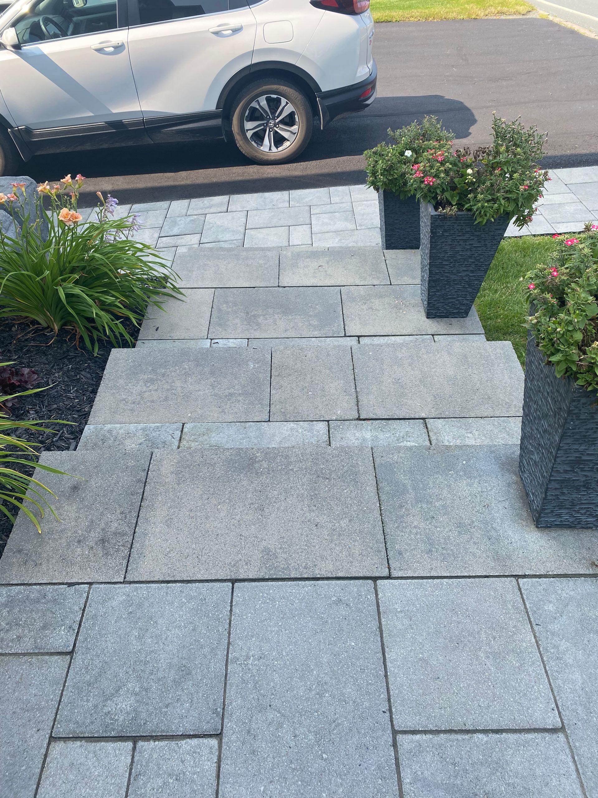 Une voiture est garée sur le bord de la route à côté d'un passage en pierre.