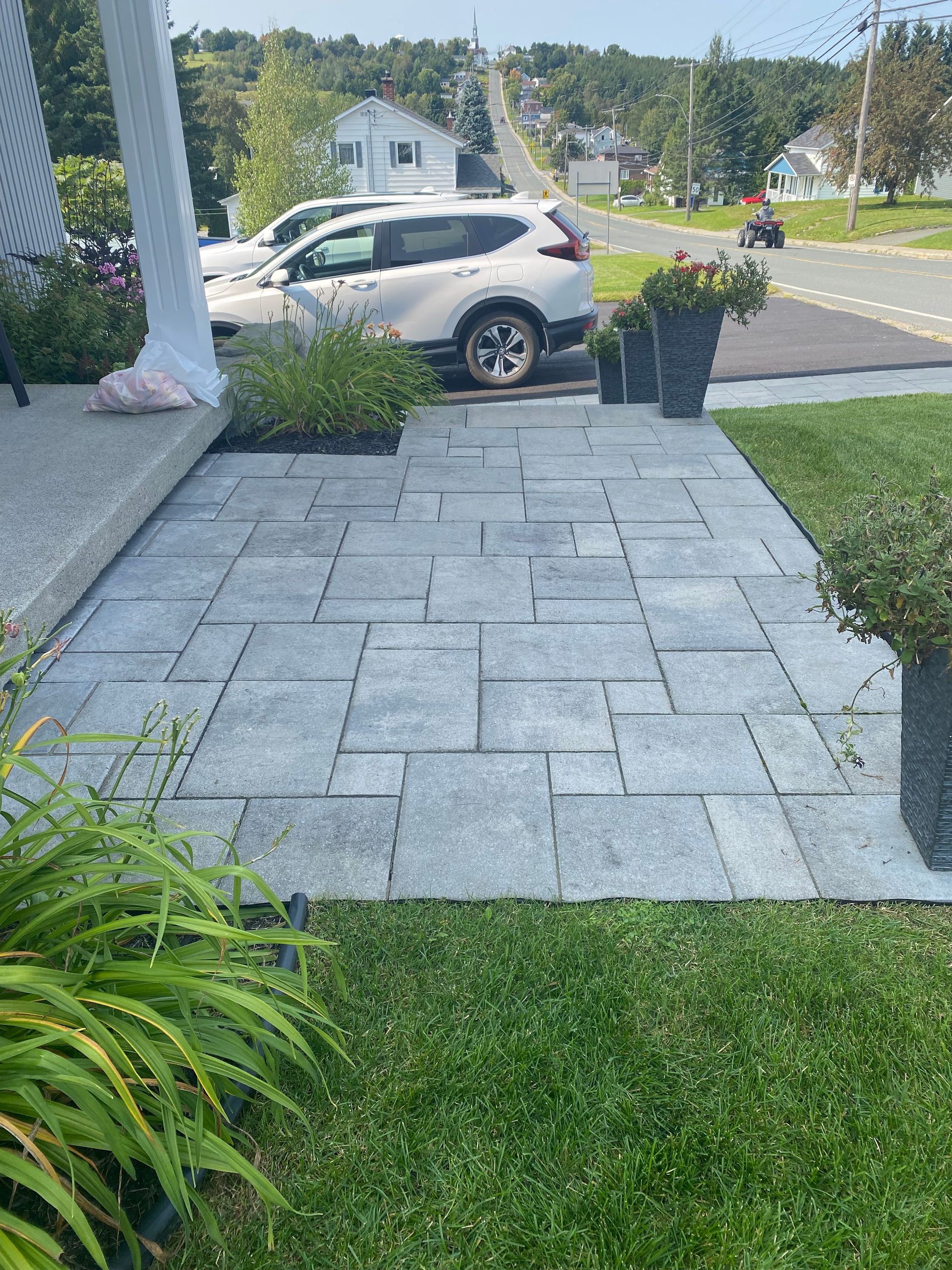 Une voiture est garée sur le bord de la route à côté d'un trottoir.