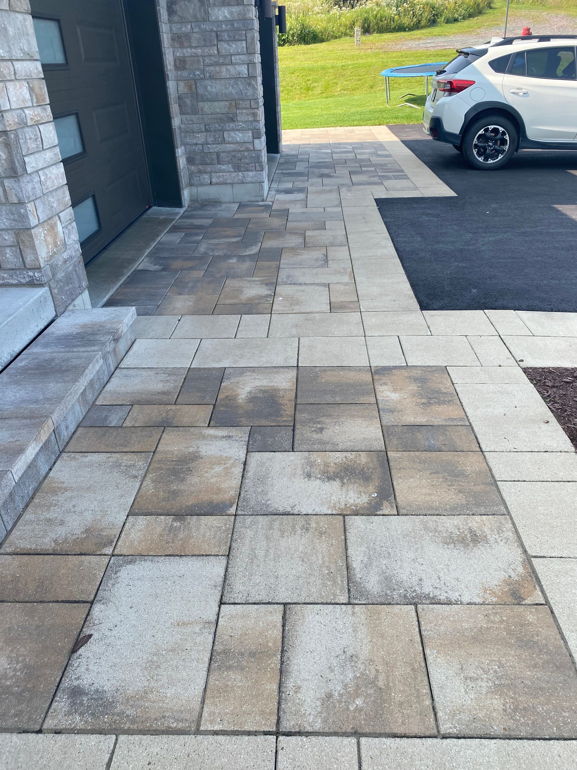 Un SUV blanc est garé devant un bâtiment en briques