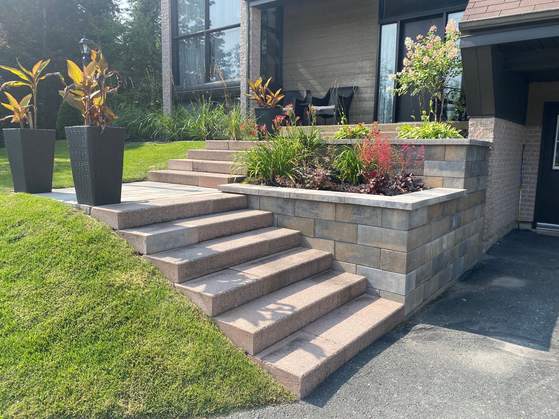 Un escalier menant à une maison avec des plantes en pot devant.