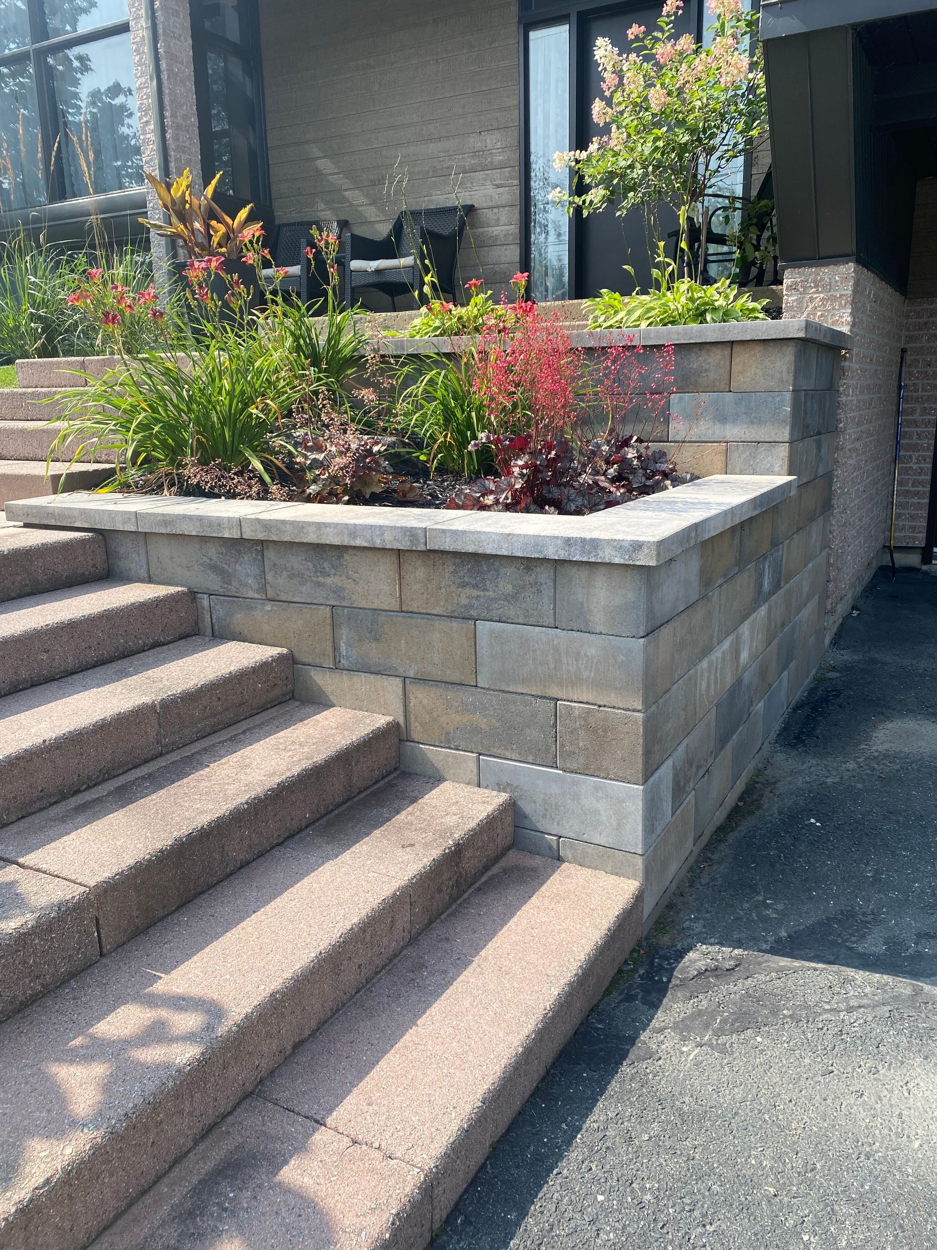 Un mur de pierre entoure un ensemble d'escaliers menant à une maison.