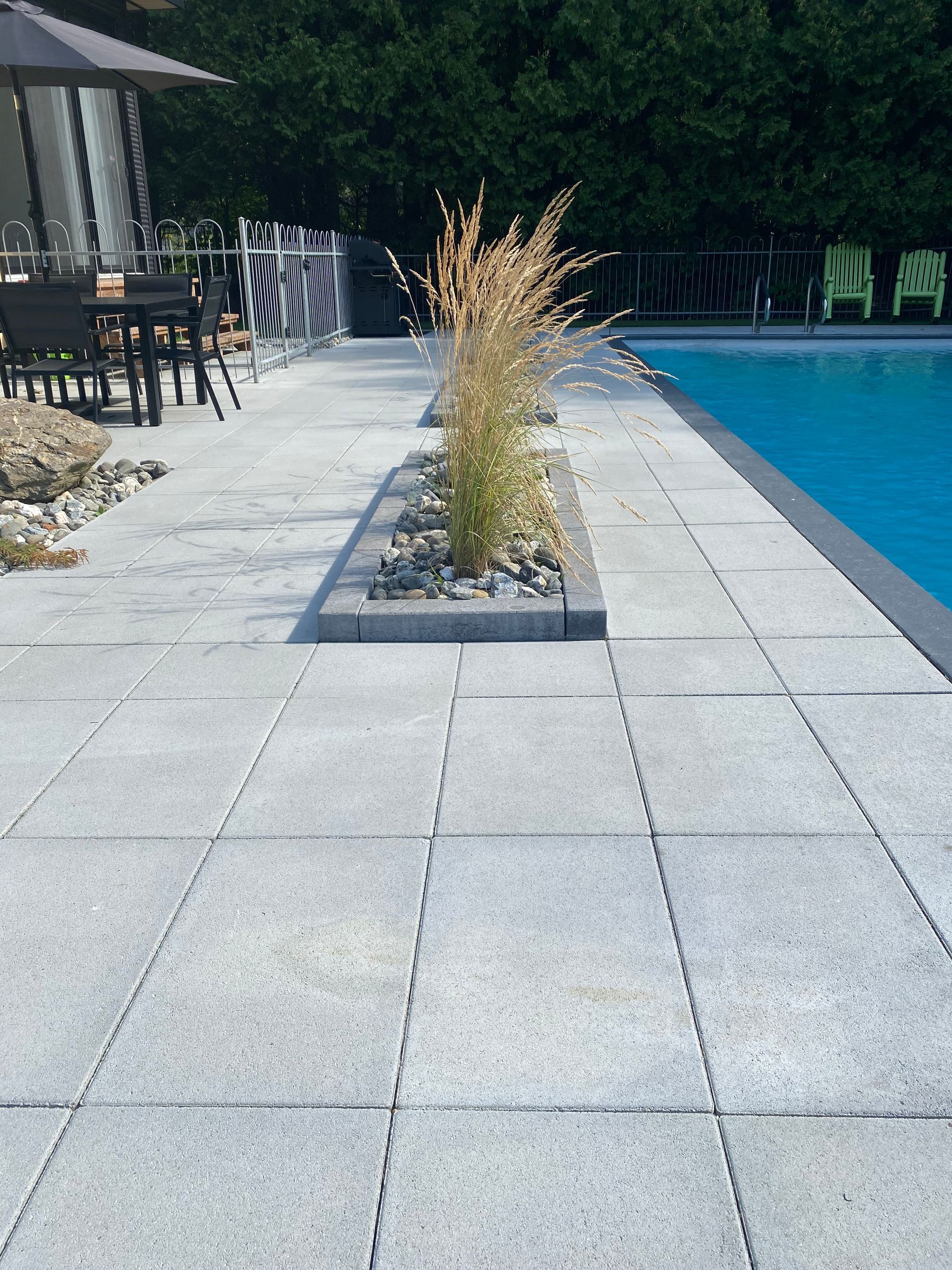 Un patio avec une piscine en arrière-plan