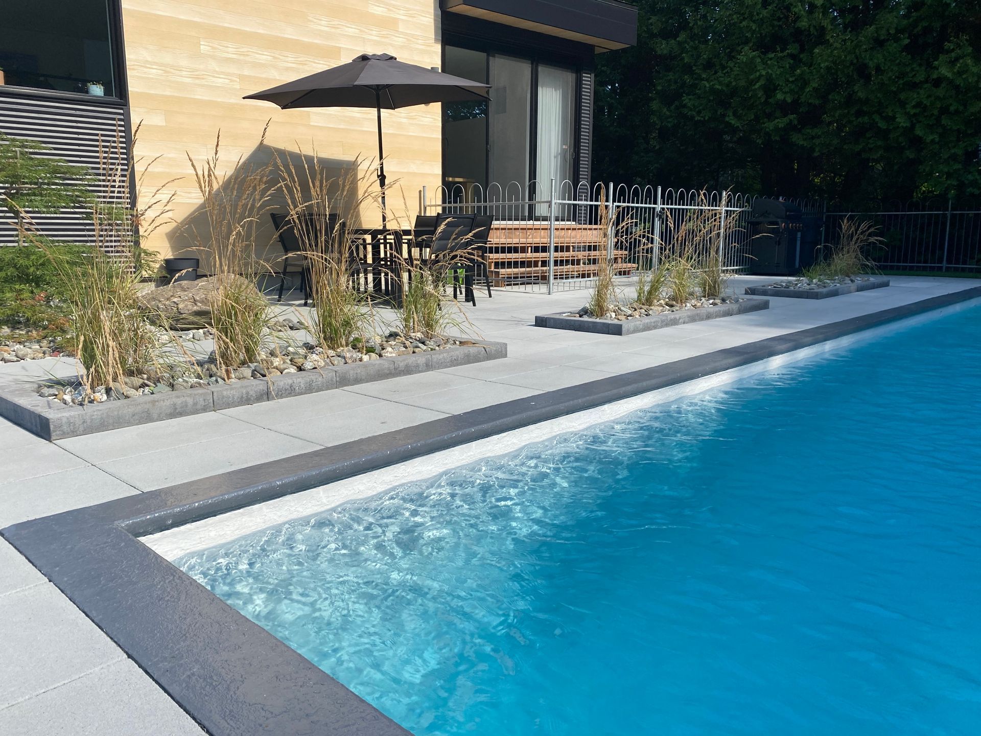 Il y a une grande piscine dans l'arrière-cour d'une maison.