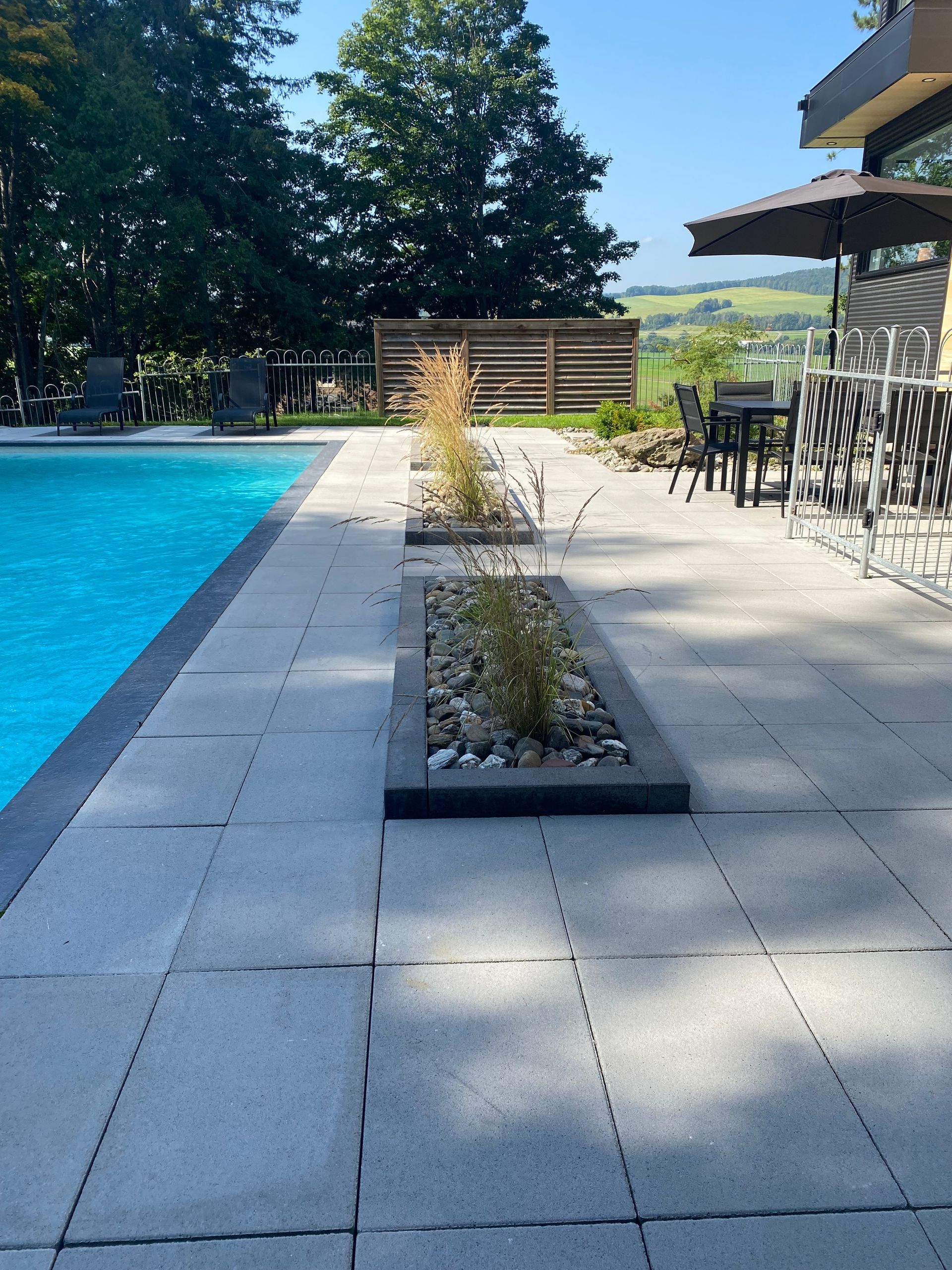 Un patio avec une piscine en arrière-plan