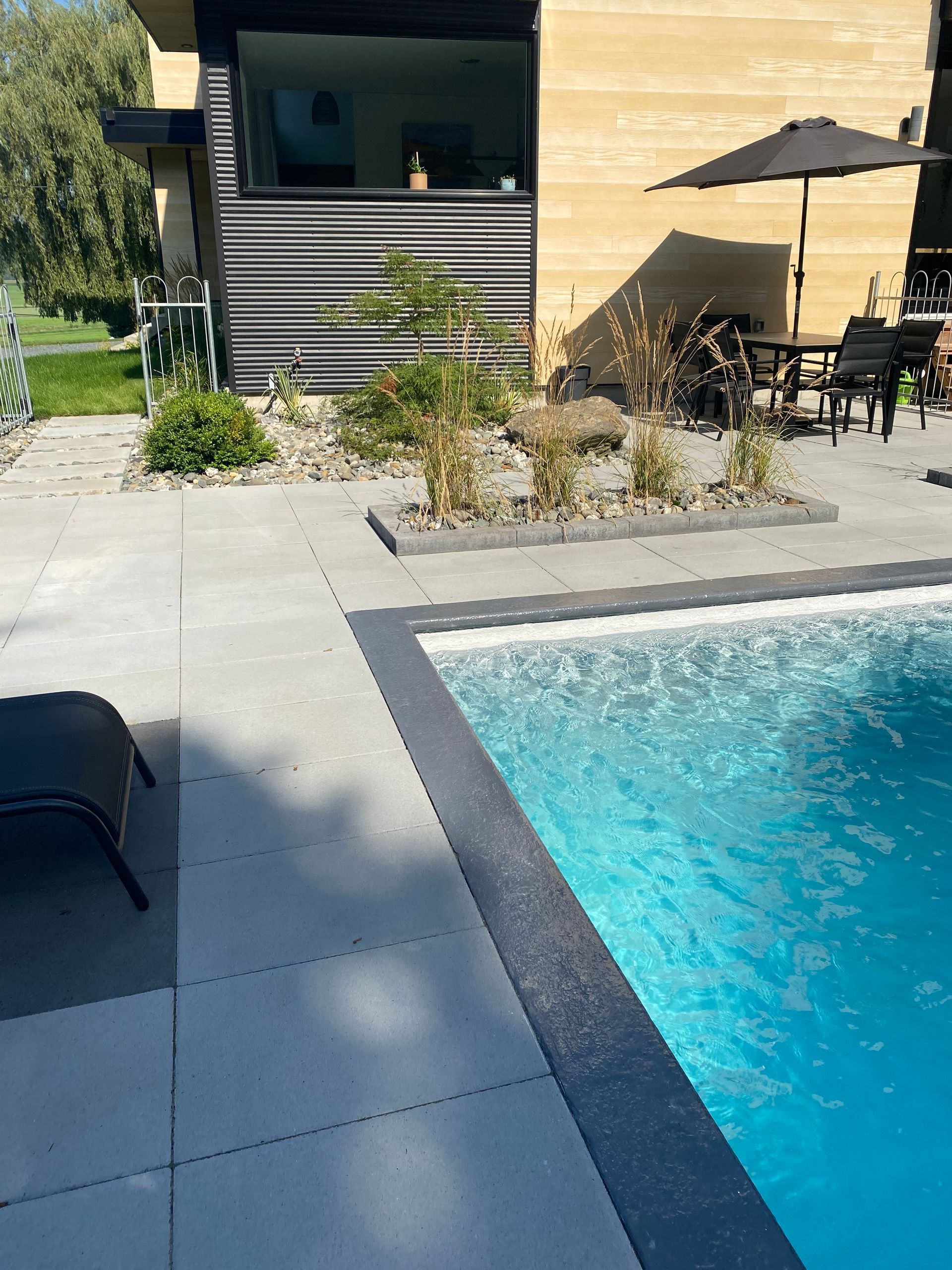 Il y a une grande piscine dans l'arrière-cour d'une maison.