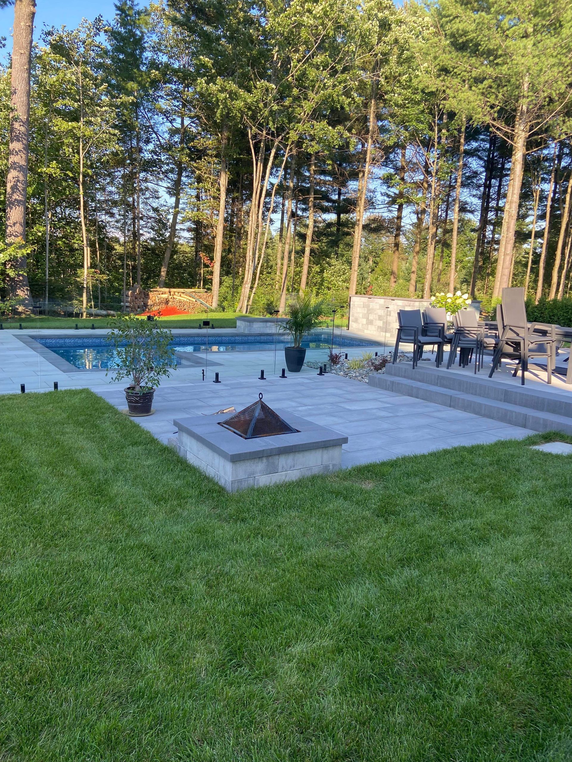 Il y a un foyer au milieu de l'arrière-cour à côté d'une piscine.