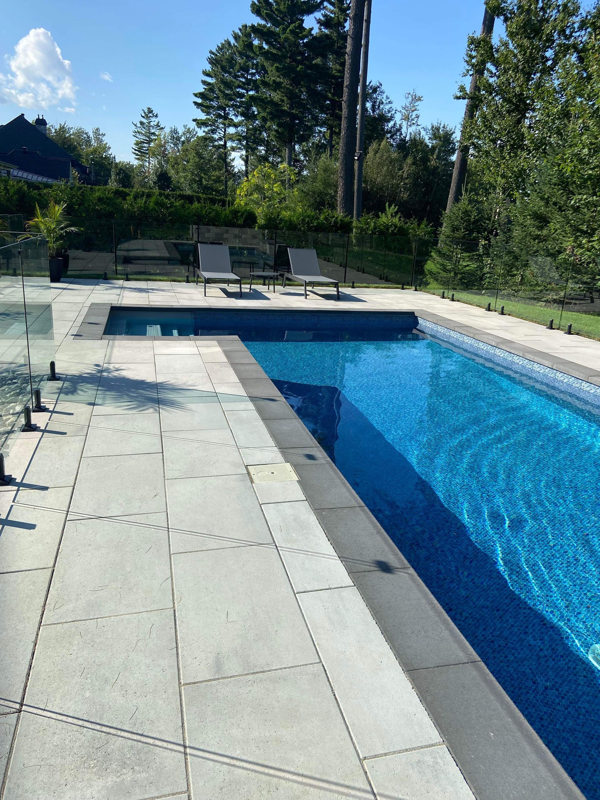 Une grande piscine entourée de chaises et d'arbres