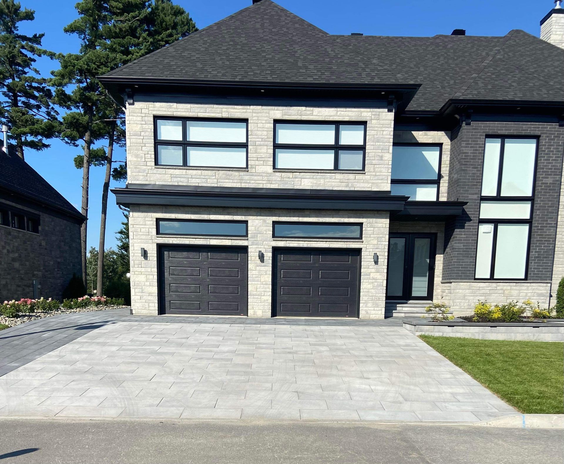 Une grande maison en briques avec une porte de garage noire