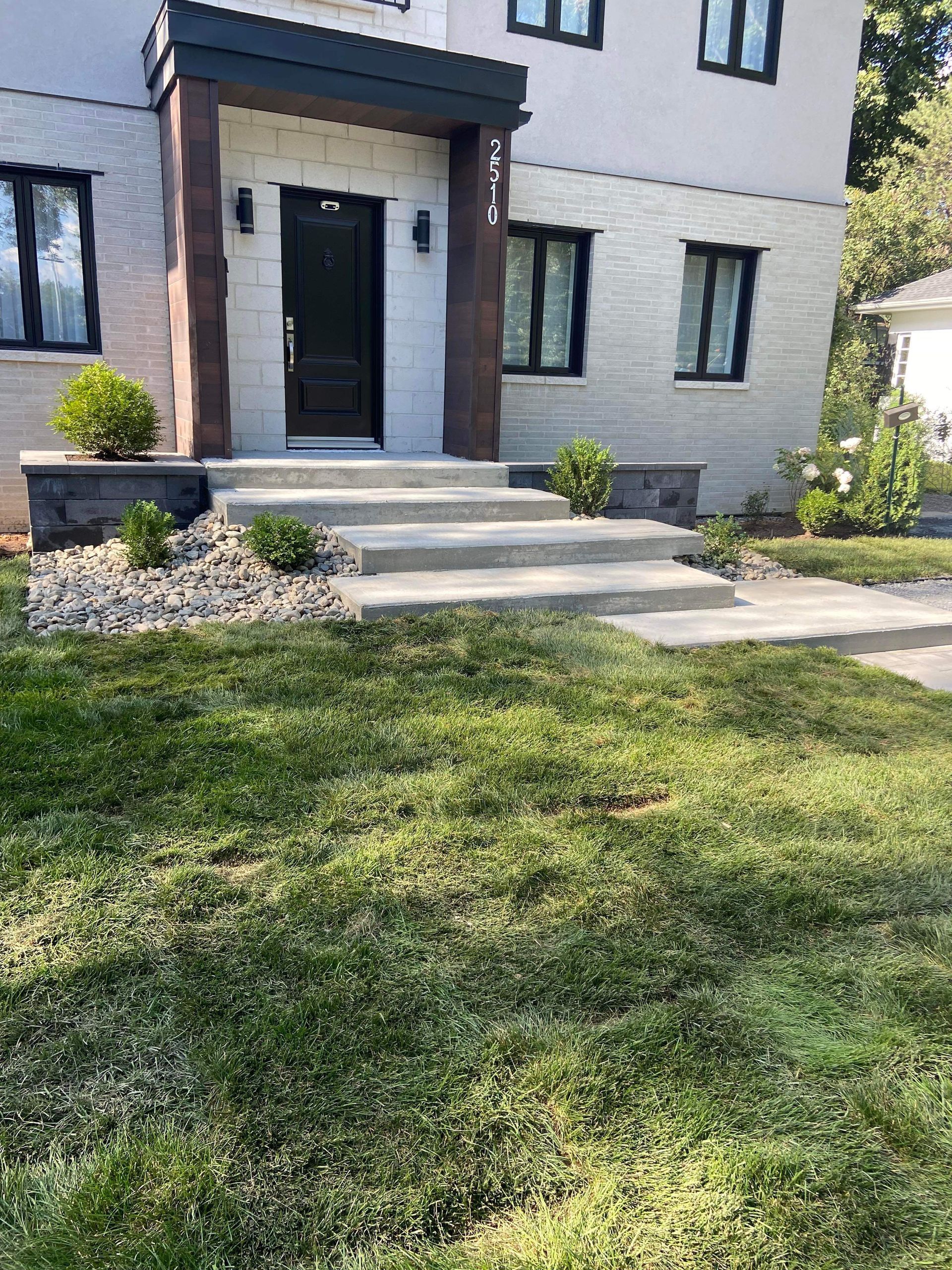 Une maison avec une pelouse verte luxuriante devant elle.