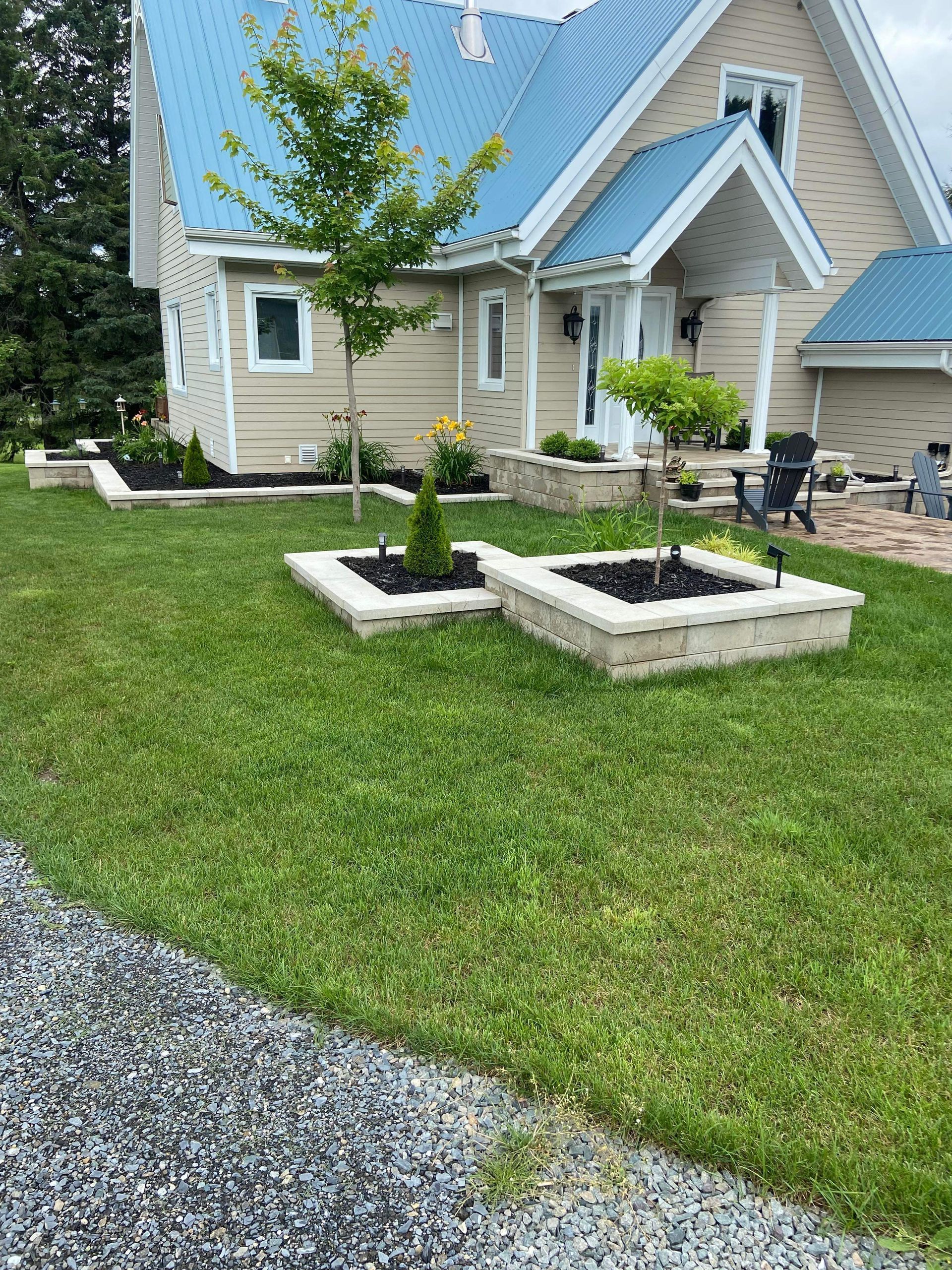 Une maison avec un toit bleu et une pelouse verte luxuriante.