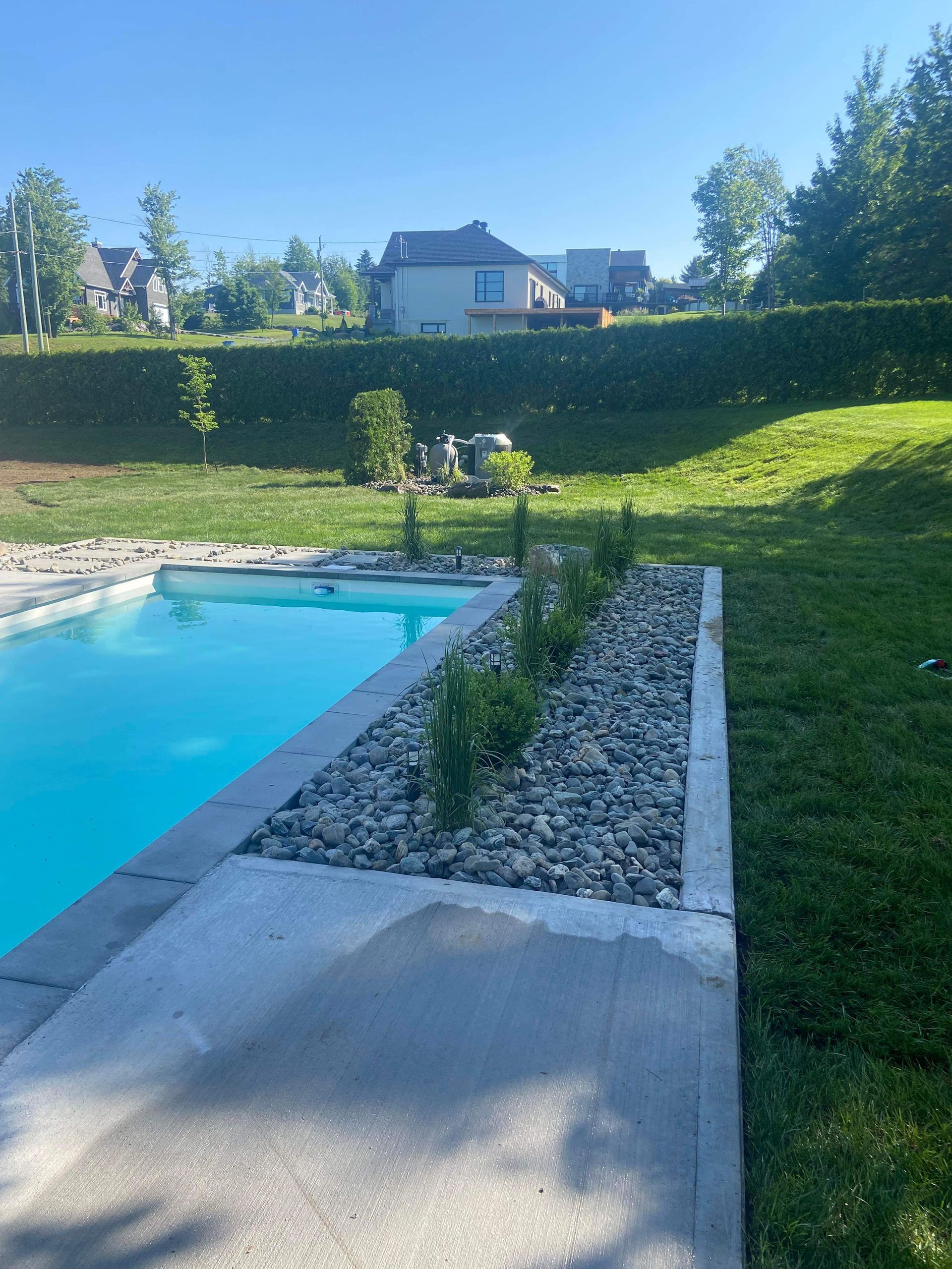 Une grande piscine dans une cour arrière avec une maison en arrière-plan.