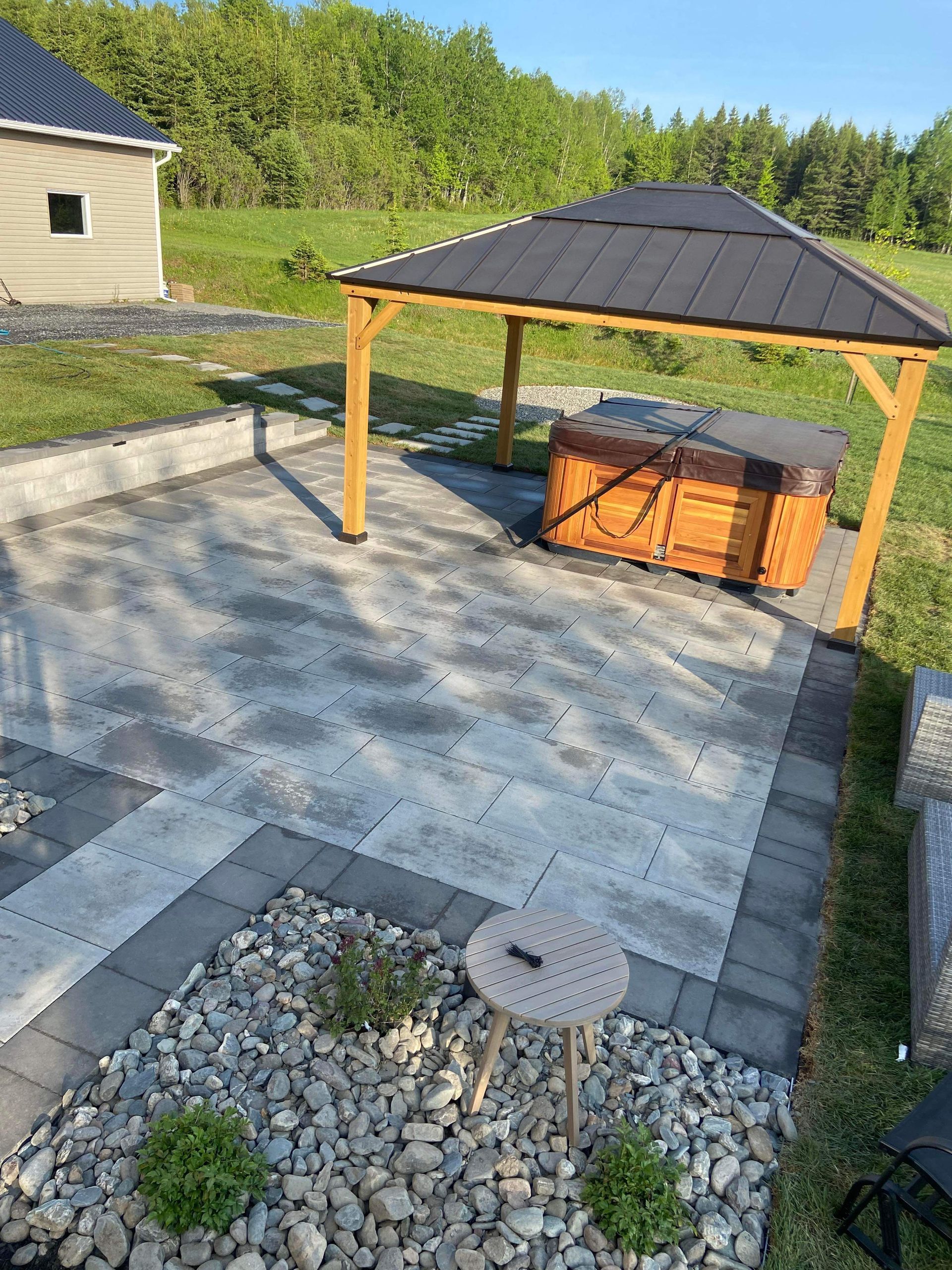 Un bain à remous est installé sous un belvédère sur une terrasse.