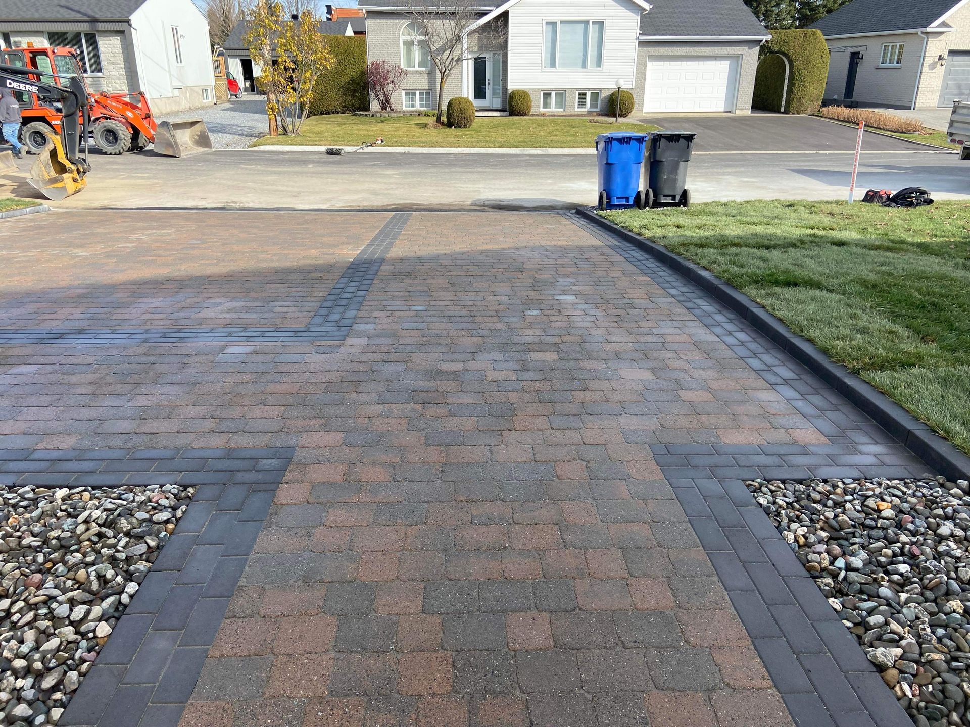 Une allée en briques est en cours de construction devant une maison.