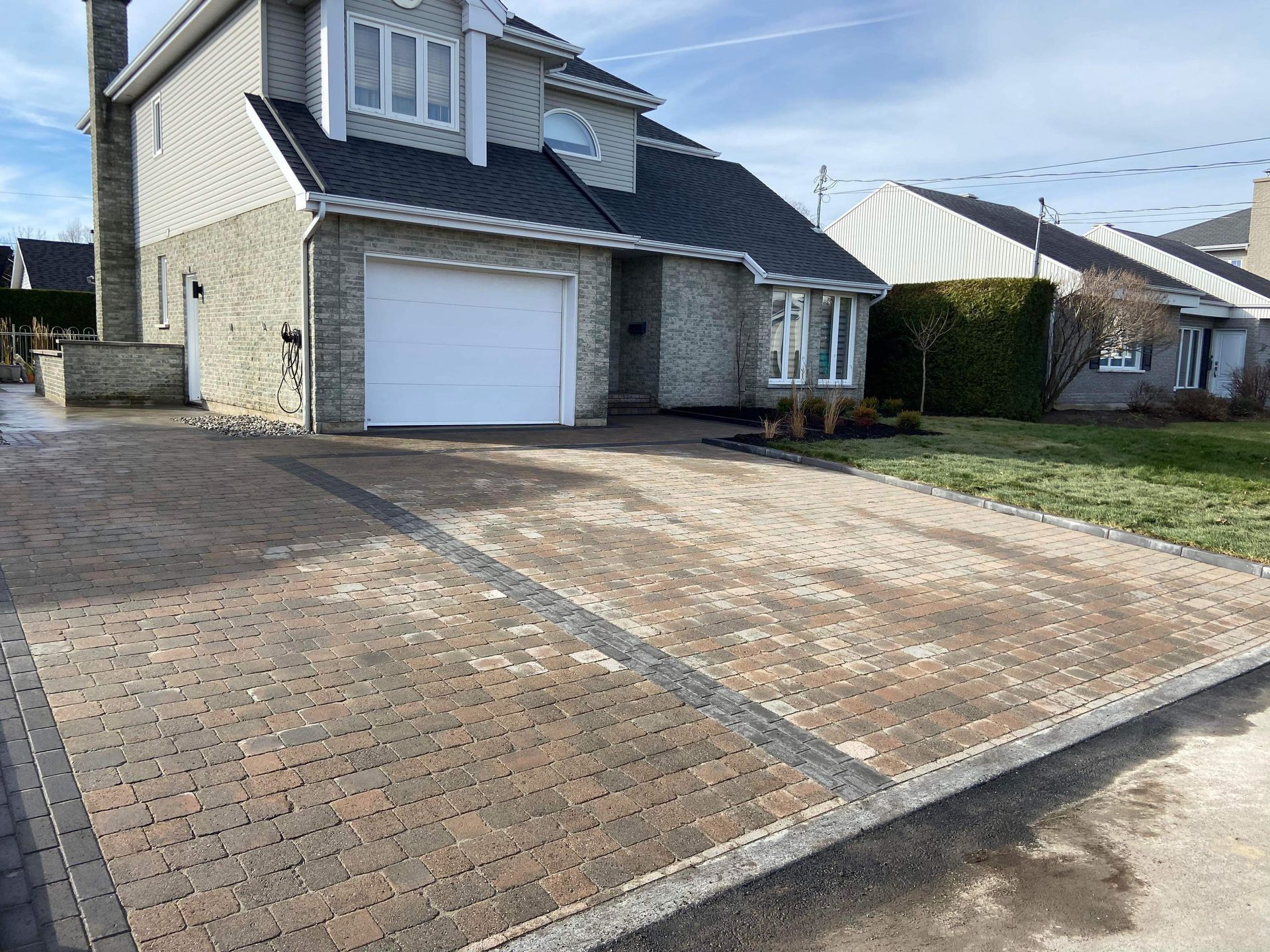 Une grande maison avec une allée en briques devant elle.