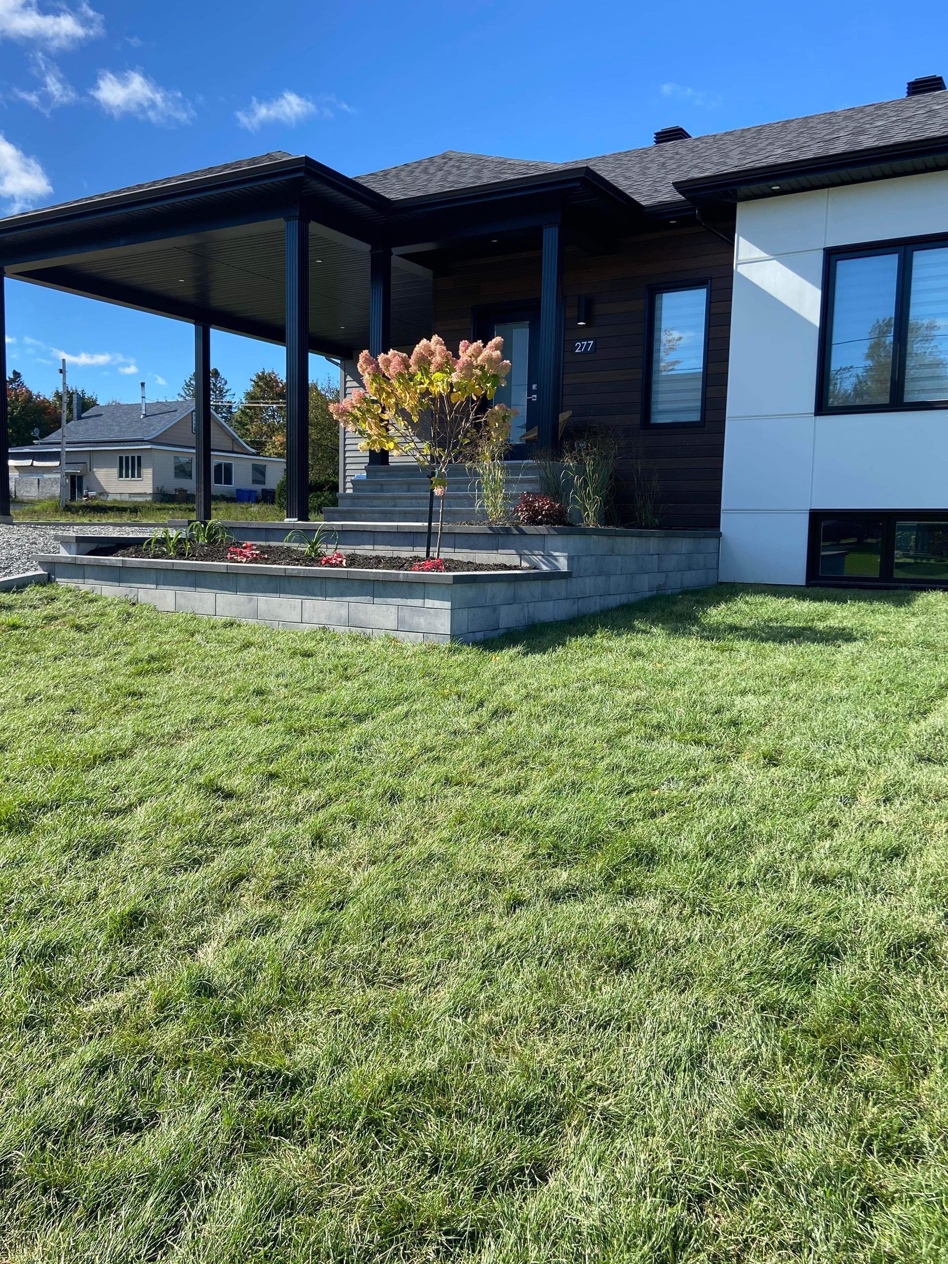 Une maison avec une pelouse verte luxuriante devant elle.