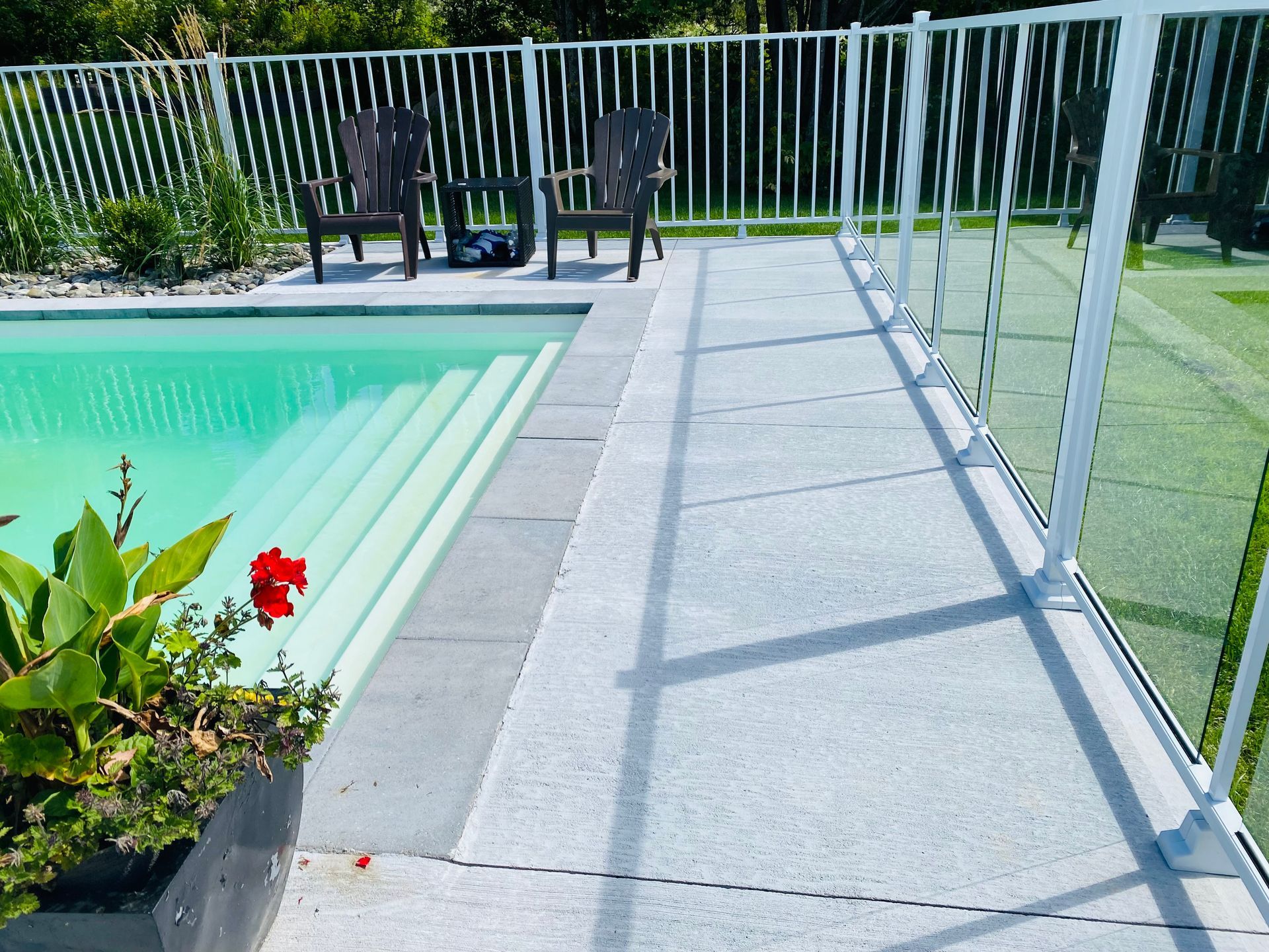 Une piscine entourée d'une clôture en verre