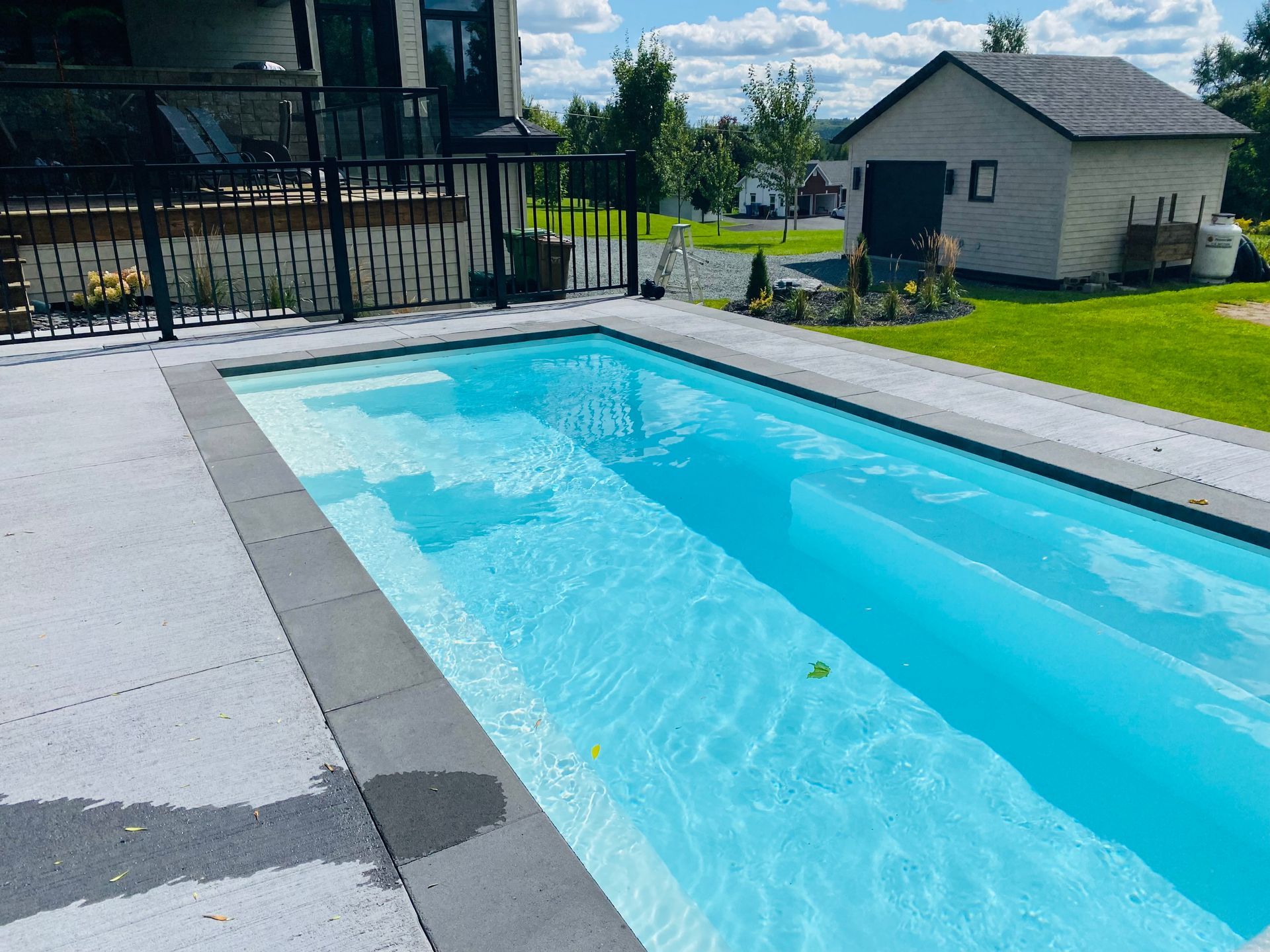 Une grande piscine avec une maison en arrière-plan