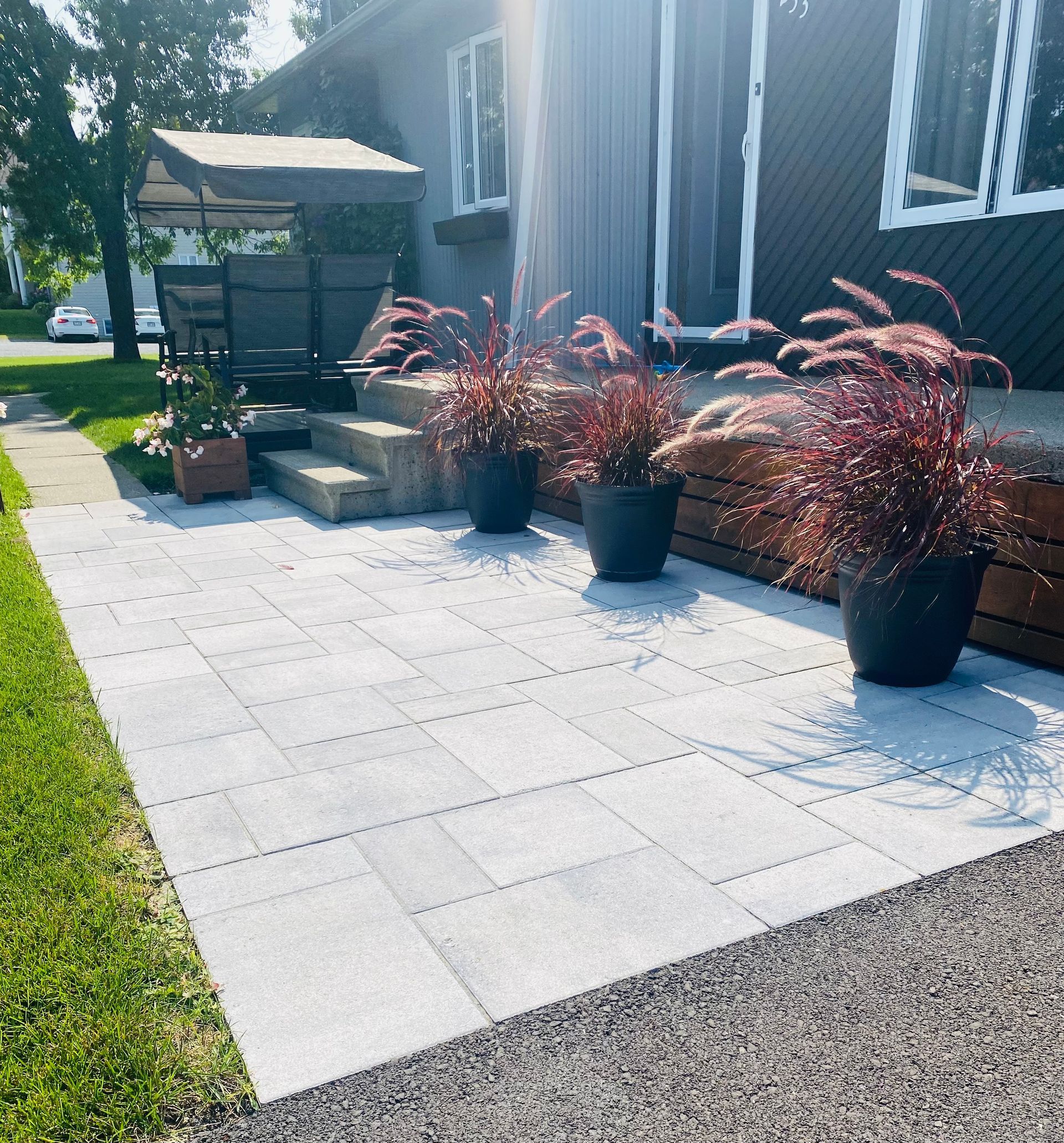 Un patio avec des plantes en pot devant une maison