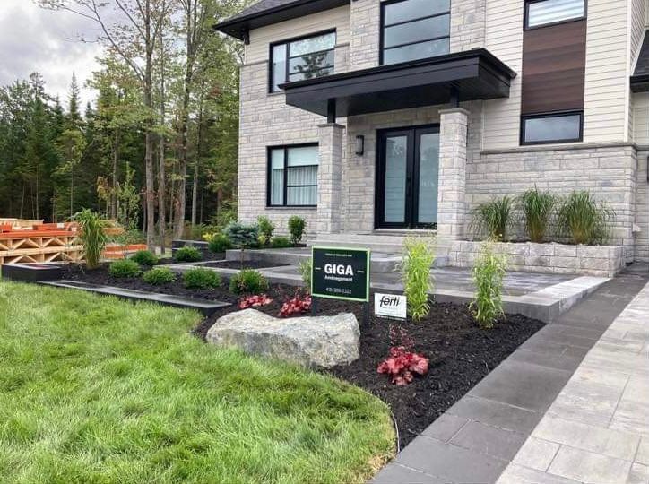 Une grande maison en briques avec un panneau devant.