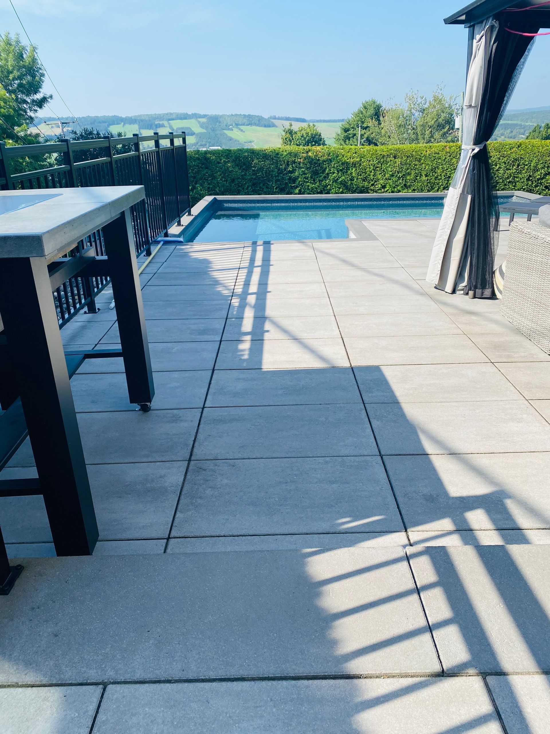 Un patio avec une piscine en arrière-plan