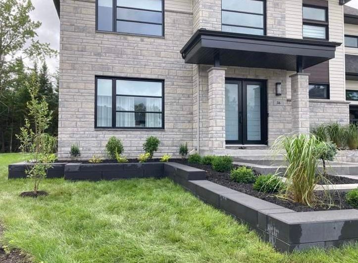 Une grande maison en briques avec une pelouse verte luxuriante devant elle.