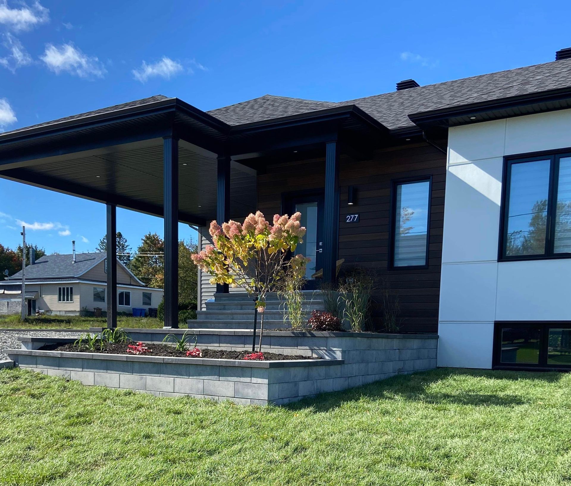Une maison avec un porche et beaucoup de fenêtres