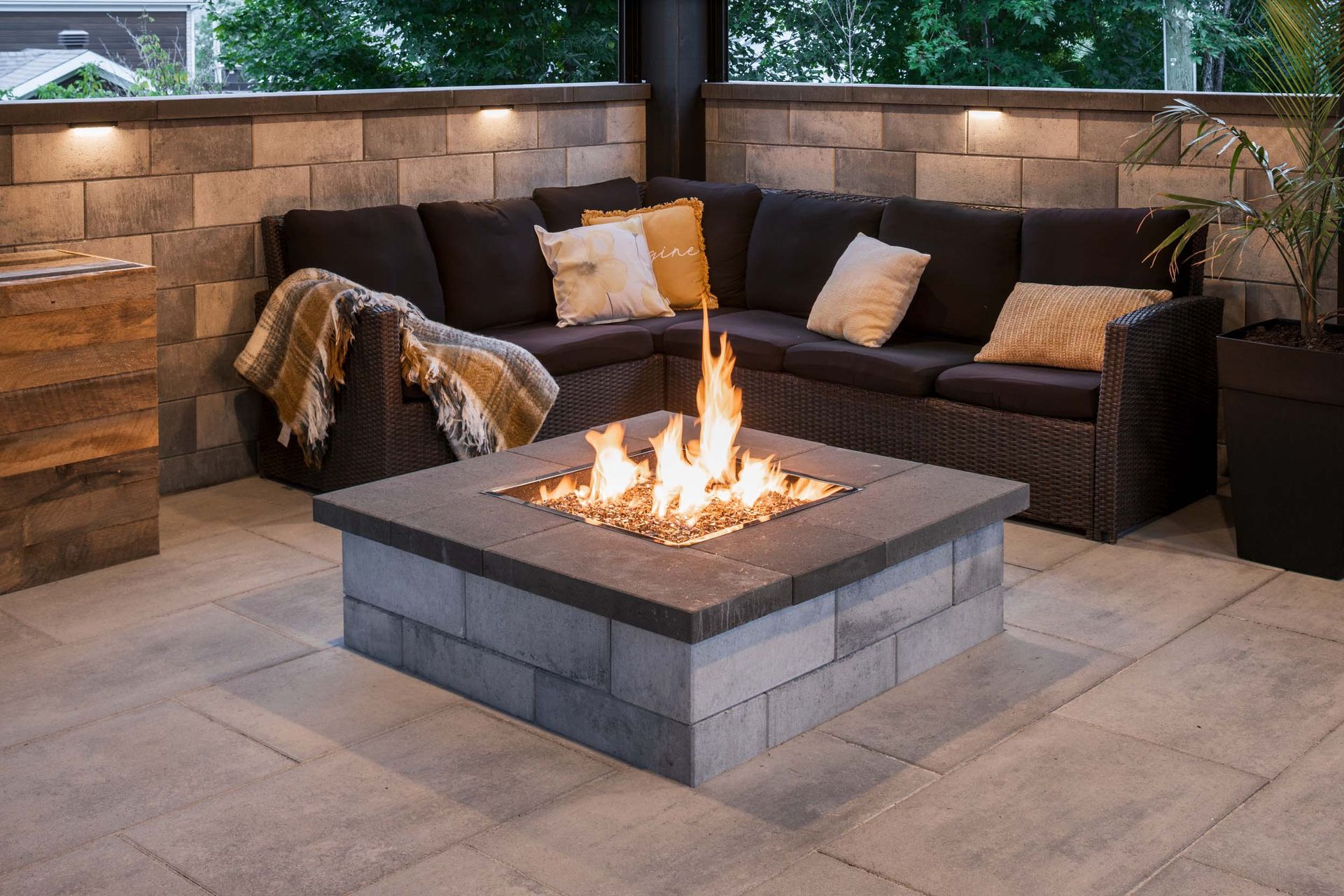 Un foyer est installé sur une terrasse à côté d'un canapé.