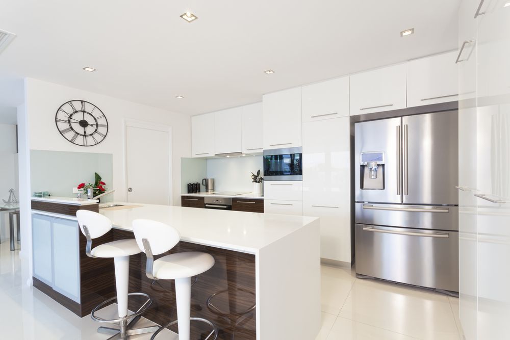 A Kitchen With Stainless Steel Appliances And A Clock On The Wall — Settle Petal Mobile Conveyancing In Laurieton, NSW