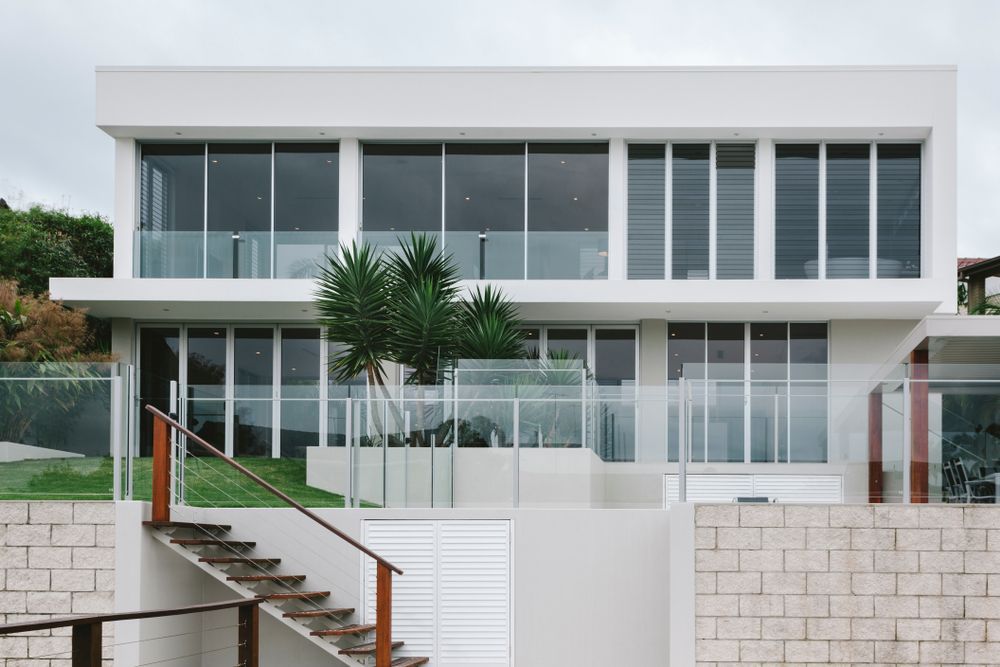 A Large White House With A Lot Of Windows And Stairs Leading Up To It — Settle Petal Mobile Conveyancing In Forster, NSW