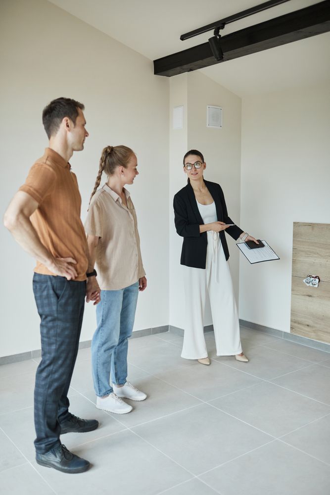 A Man And A Woman Are Standing In An Empty Room With A Woman — Settle Petal Mobile Conveyancing In Wallabi Point, NSW
