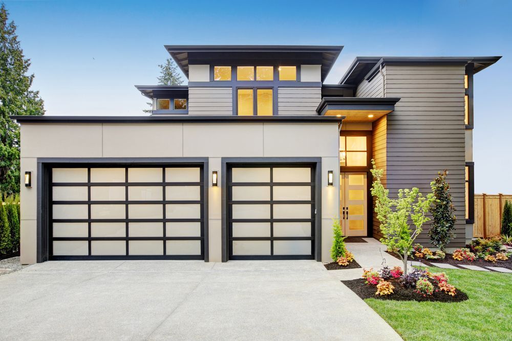 A Modern House With Two Garage Doors And A Large Driveway — Settle Petal Mobile Conveyancing In Wingham, NSW