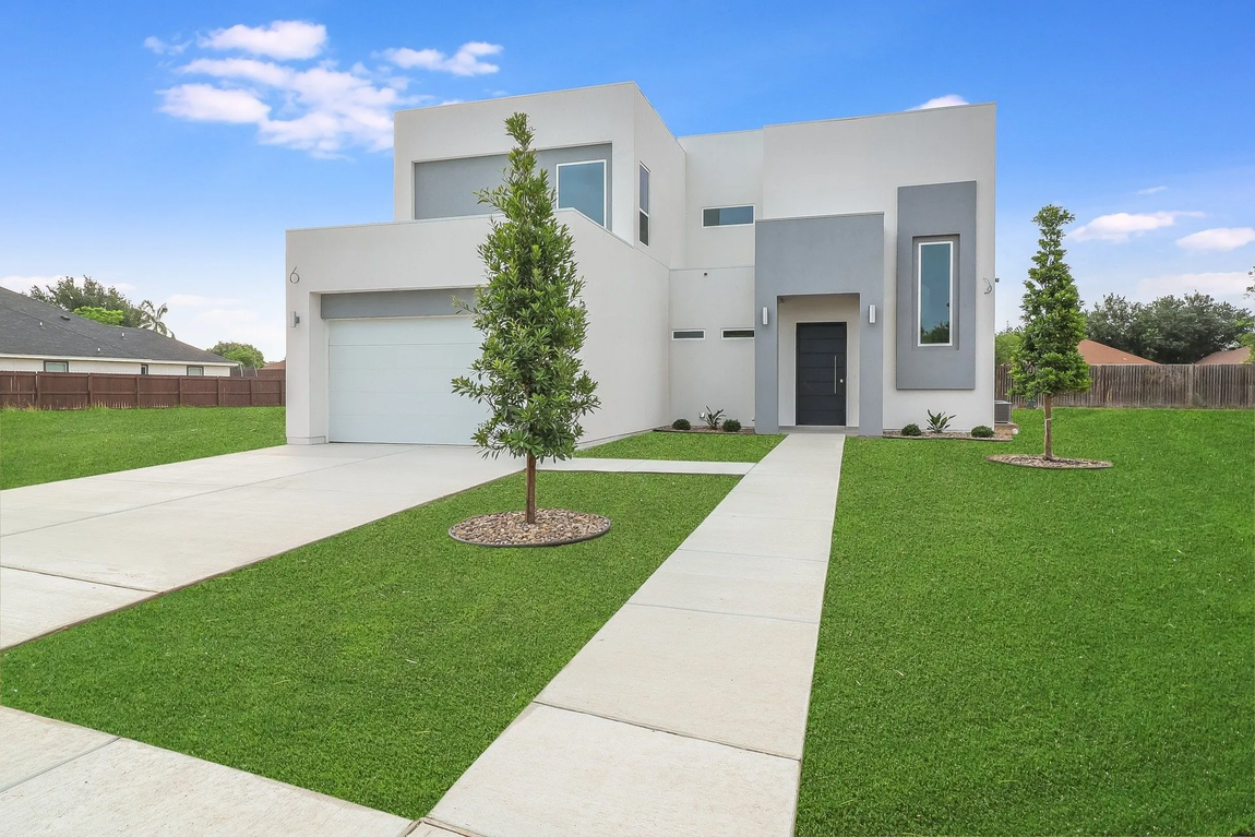 elegant house with large front yard and trees.