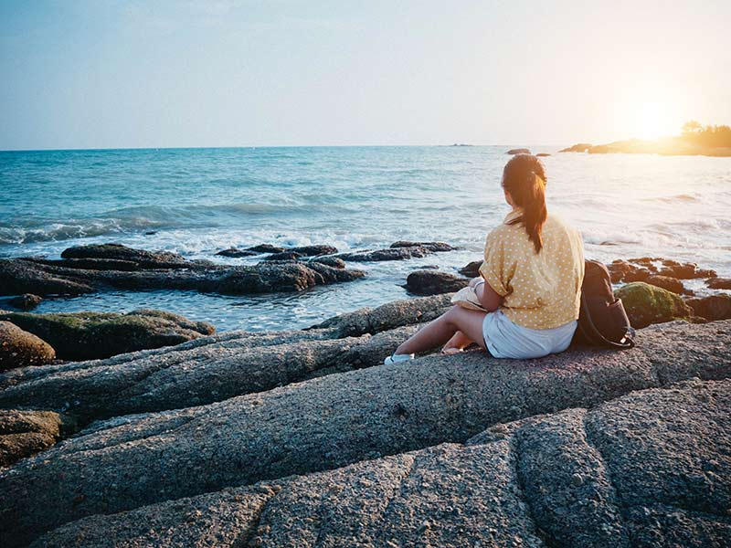 woman sitting by beach