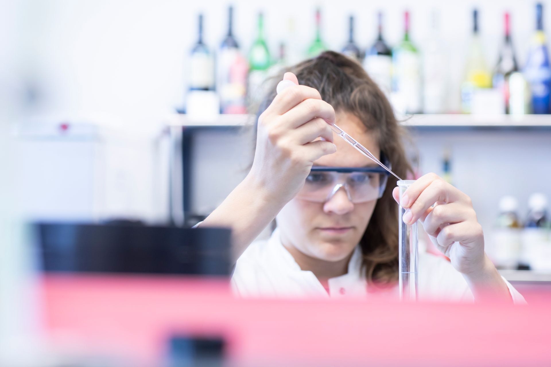 Eine Chemielaborantin pippetiert eine Flüssigkeit