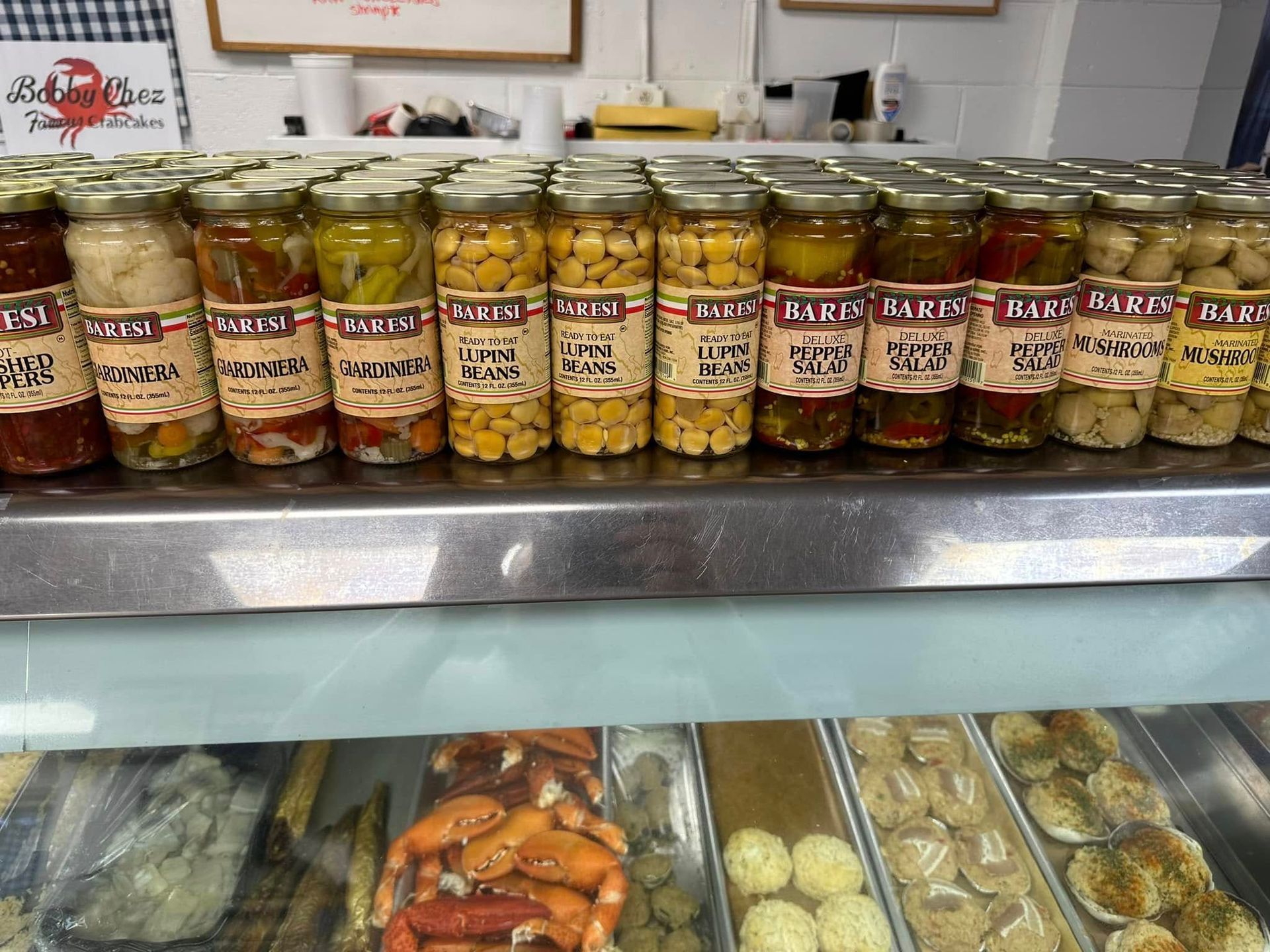 Display case with jars of pickles and prepared foods.