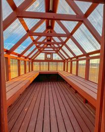 A greenhouse with a wooden floor and a clear roof