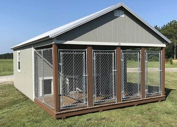 A large dog kennel is sitting in the middle of a grassy field.