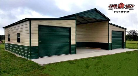 A metal garage with green doors is sitting on top of a lush green field.