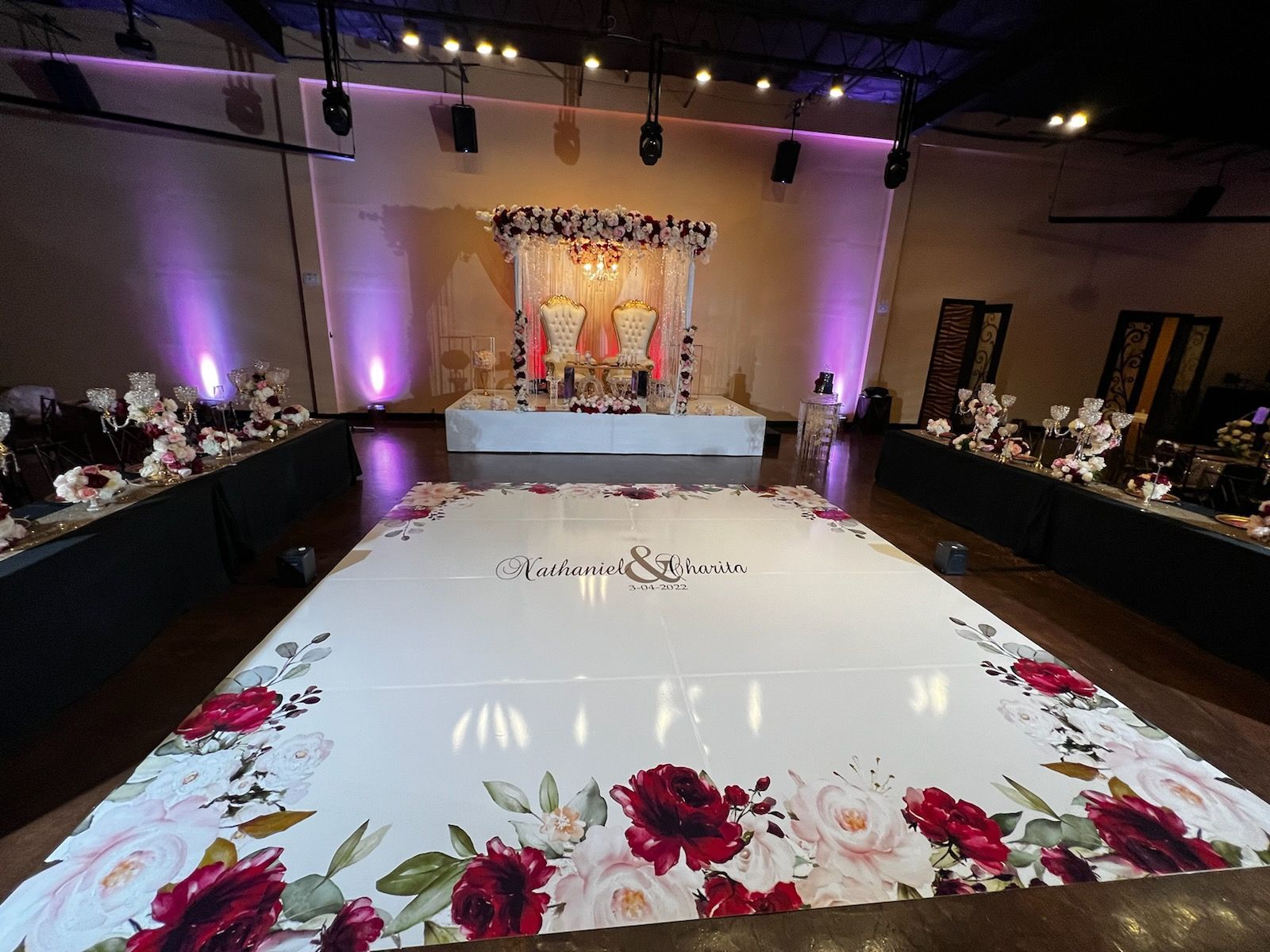 Wedding reception stage with floral decor and a decorated dance floor.