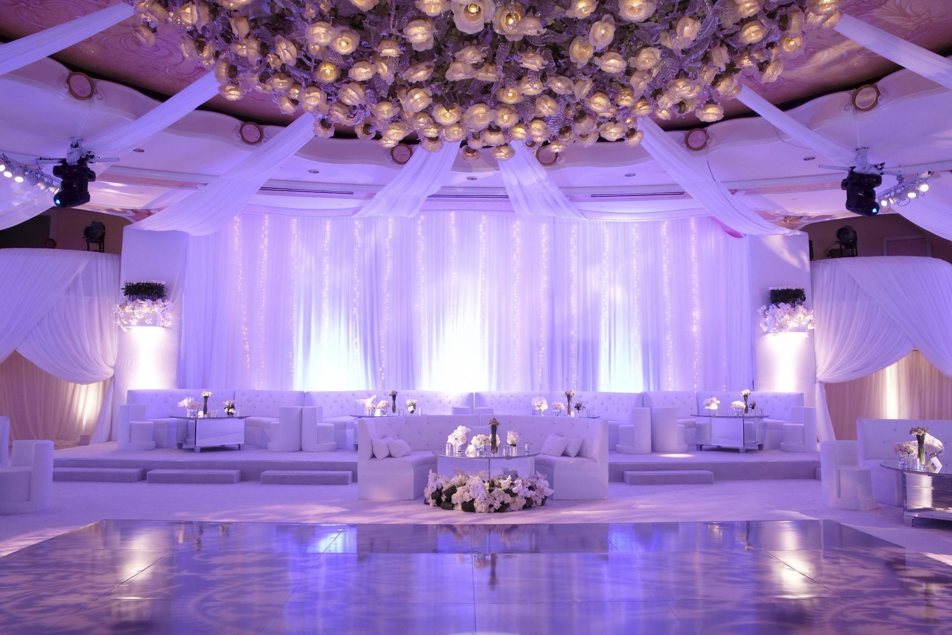 A large room with a dance floor and a purple backdrop.