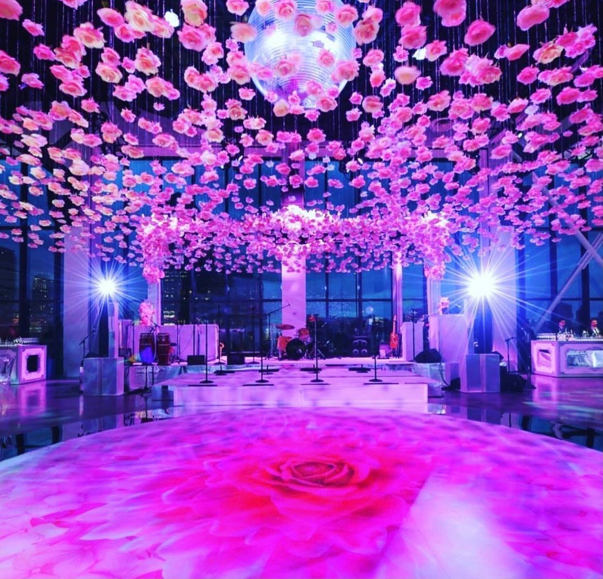 A dance floor with a rose on it and flowers hanging from the ceiling.
