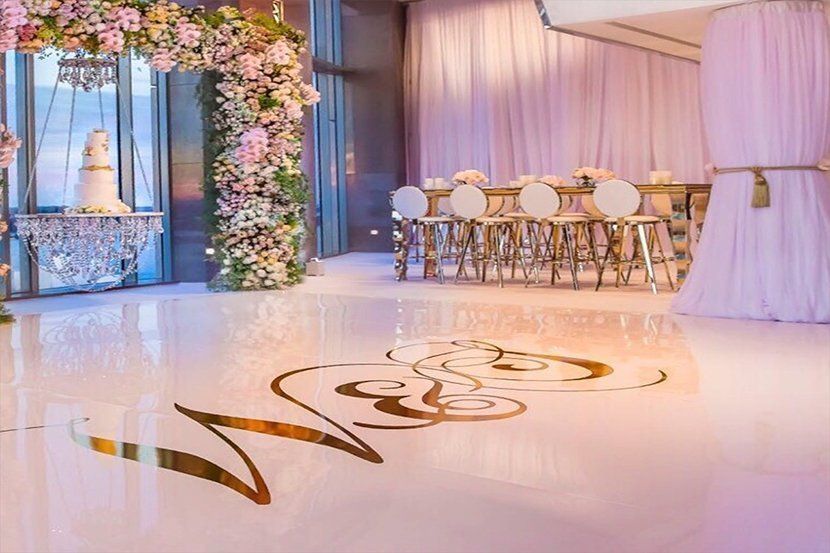 A wedding reception with a bride and groom's initials on the floor.