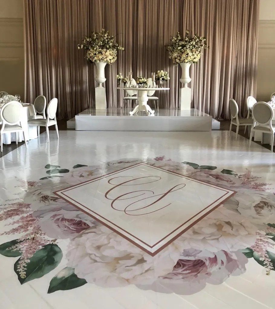 A dance floor with a monogram and flowers on it.