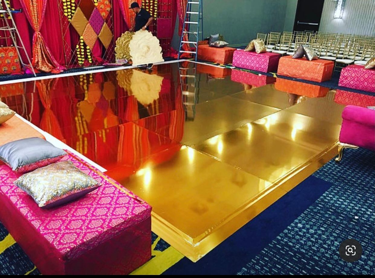A room with a gold floor and a lot of pillows on it.