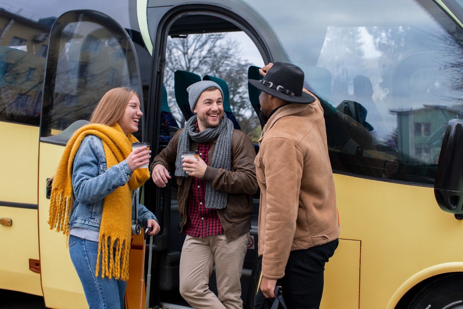 A group of people are standing next to a bus.