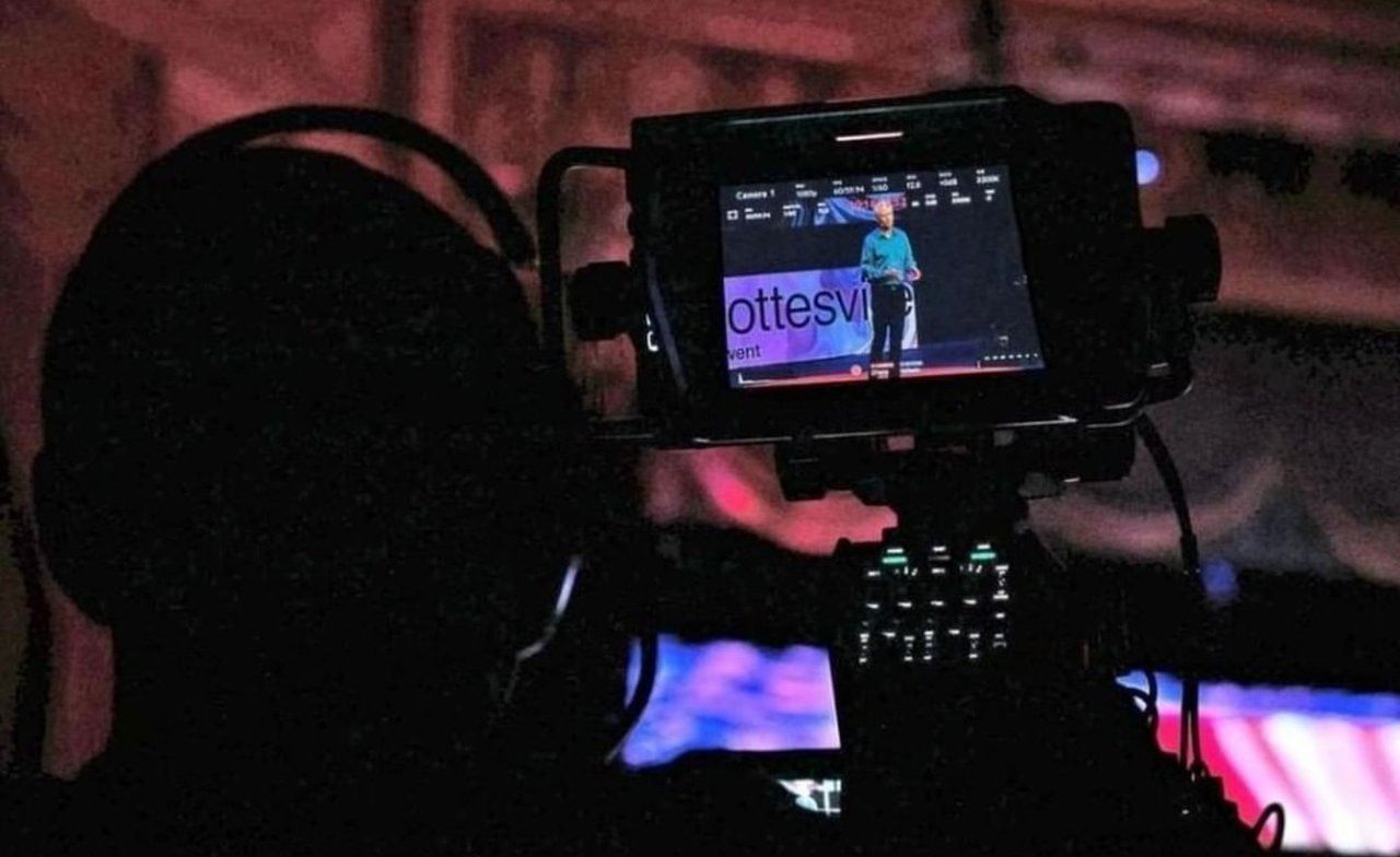 A man capturing a live stream of another man having a conference.