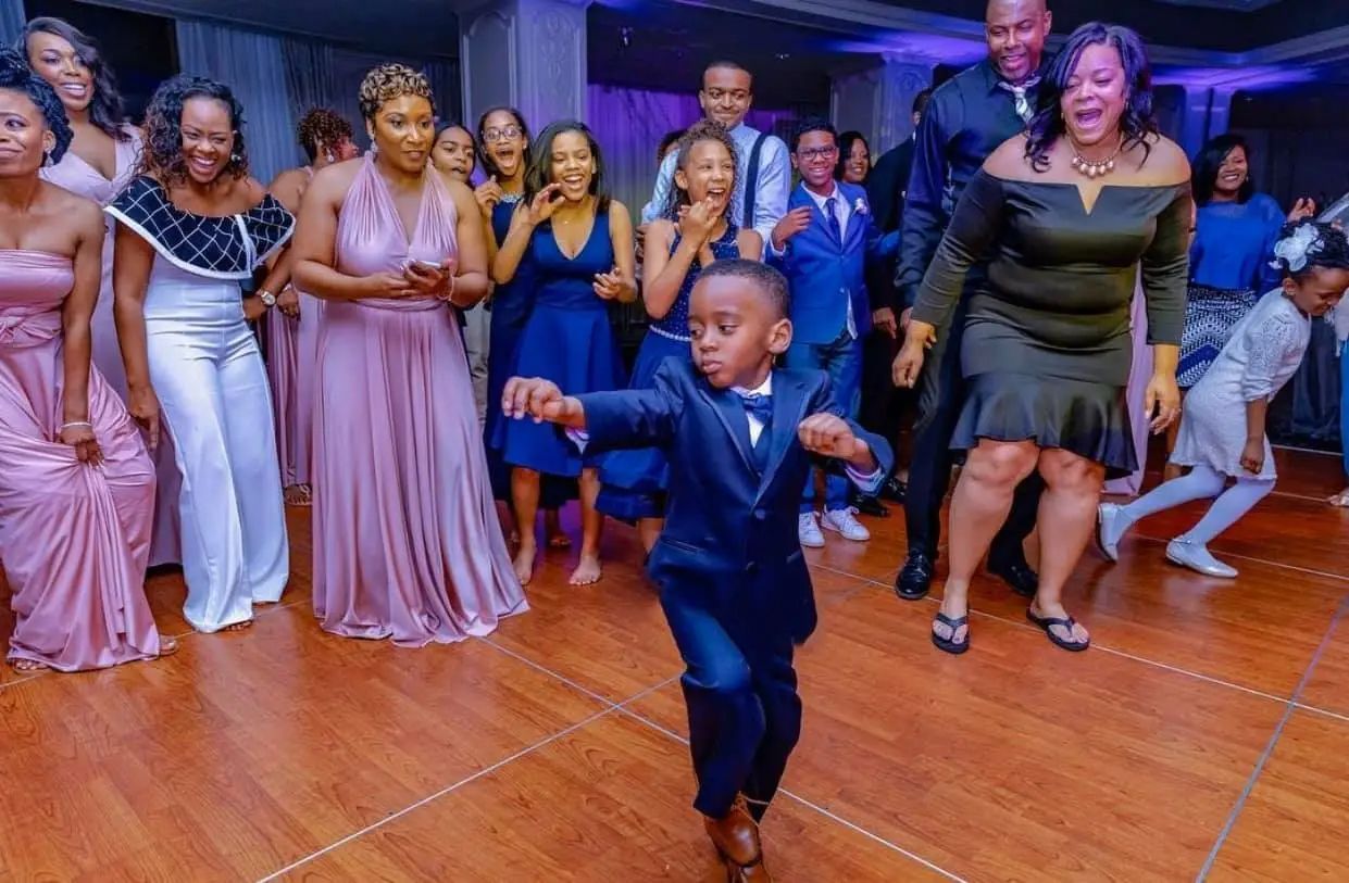 A group of people are dancing on a dance floor at a wedding reception.