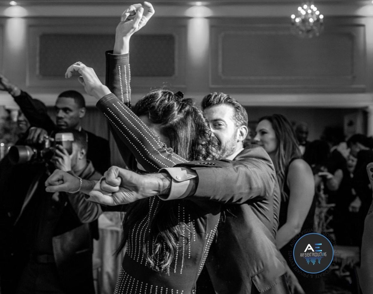 A black and white photo of a man and woman dancing at a wedding reception.