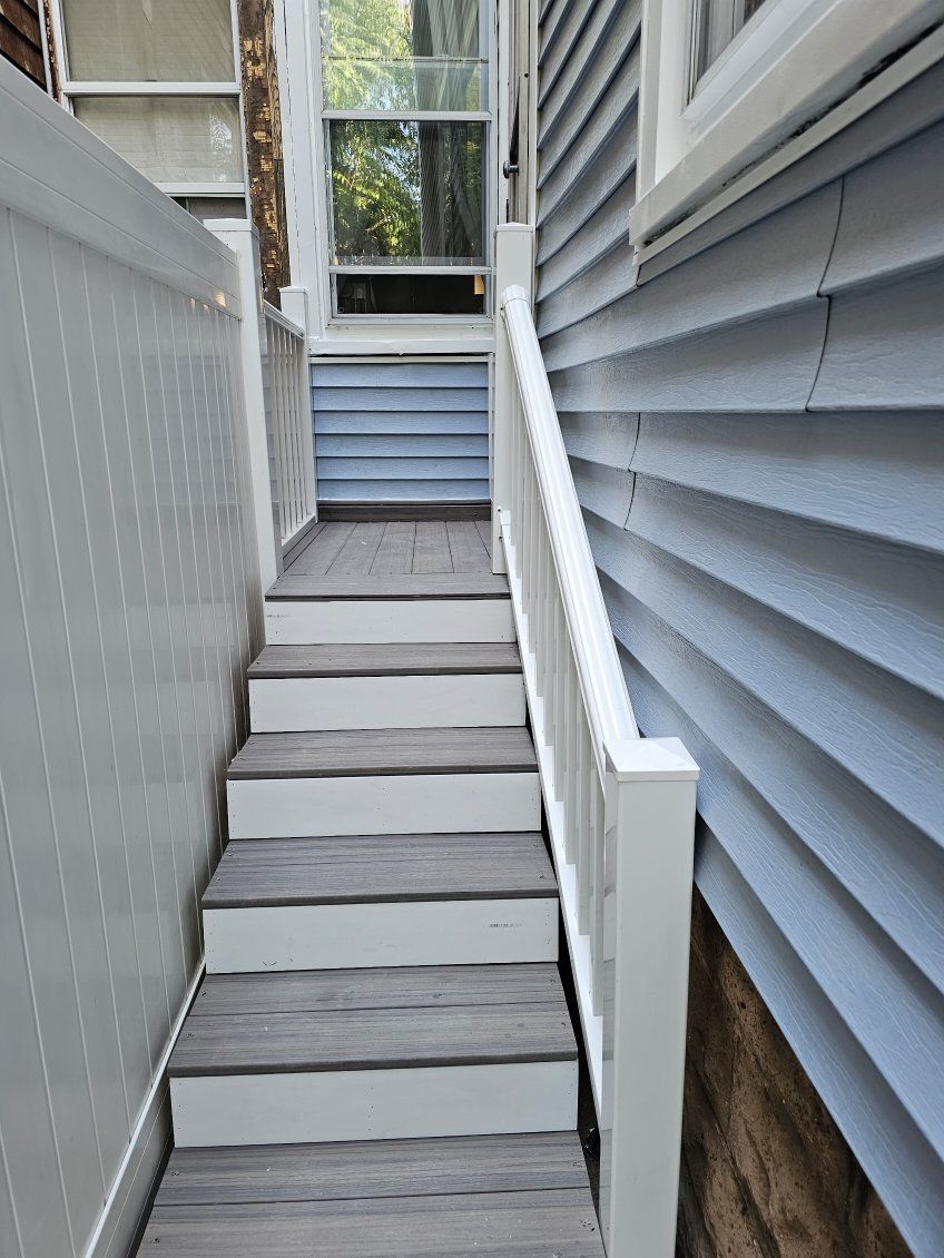 A set of stairs leading up to a house with blue siding