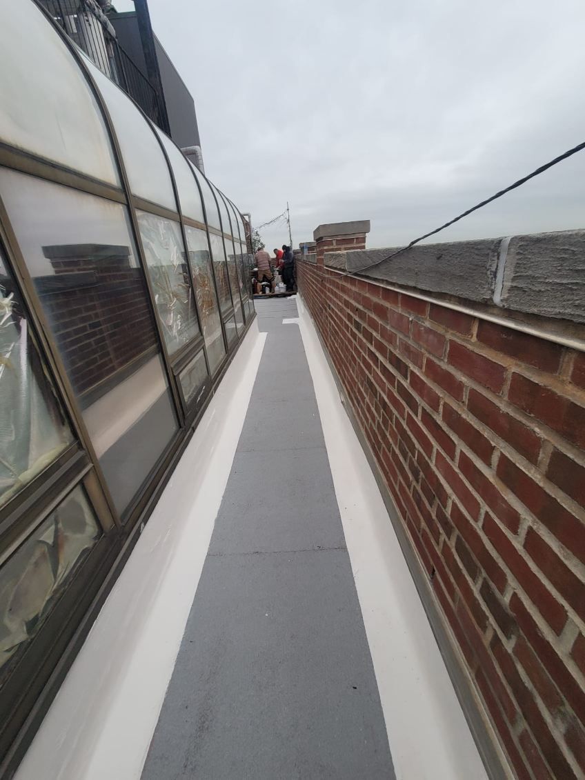 A long walkway with a brick wall on the side of it